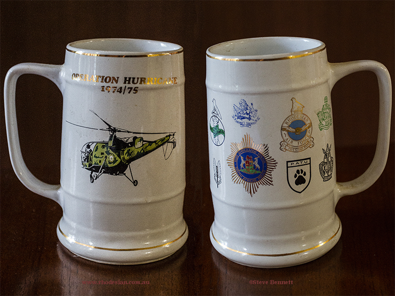Photograph of beer mug for Operation Hurricane 1974 - 75 with logos of South African Police, Rhodesian Air Force, Rhodesian Light Infantry, Special Air Services, Rhodesian African Rifles, JOC Mount Darwin, British South Africa Police, Police Anti Terrorist Unit